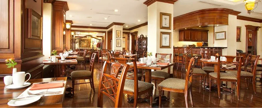 Café Plaza Grande en Quito: interior elegante con mobiliario de madera y barra de bar.