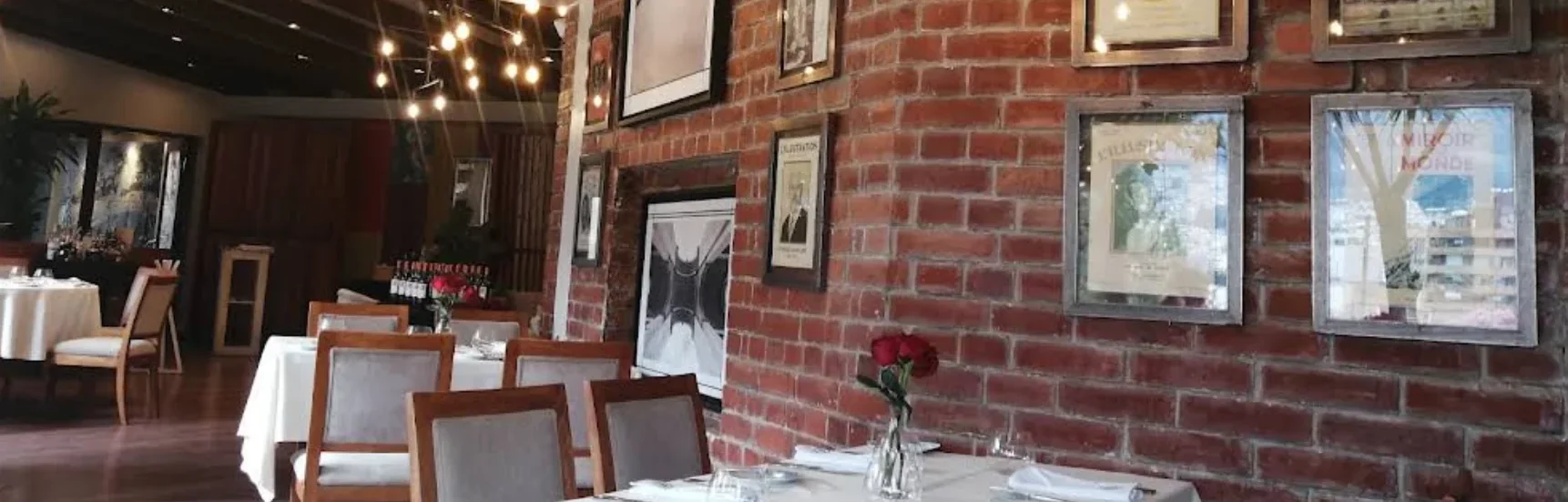 Restaurante Chez Jerome en Quito: interior elegante con pared de ladrillo visto.